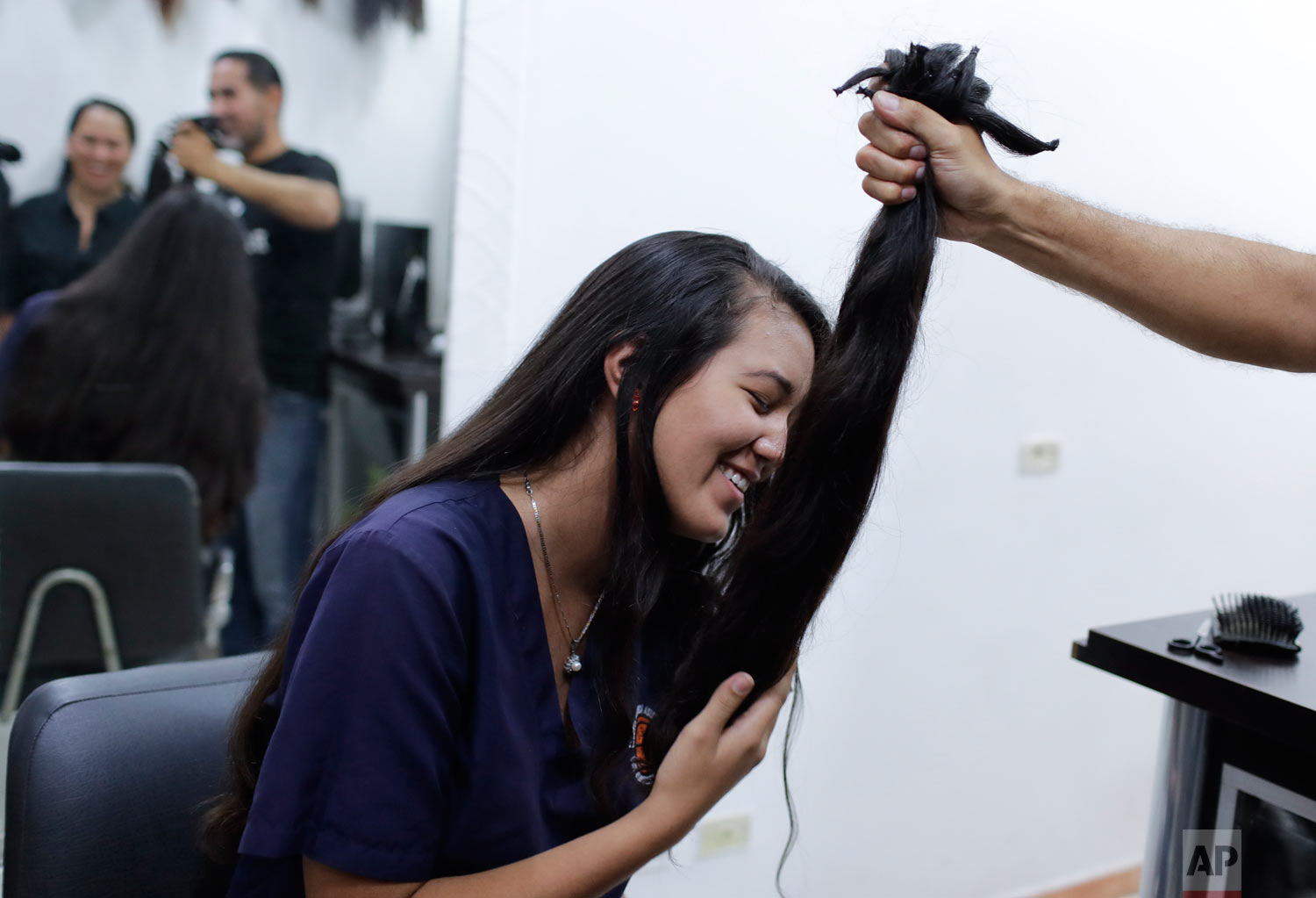 Valery Díaz holds her cut off locks. (AP Photo/Natacha Pisarenko)