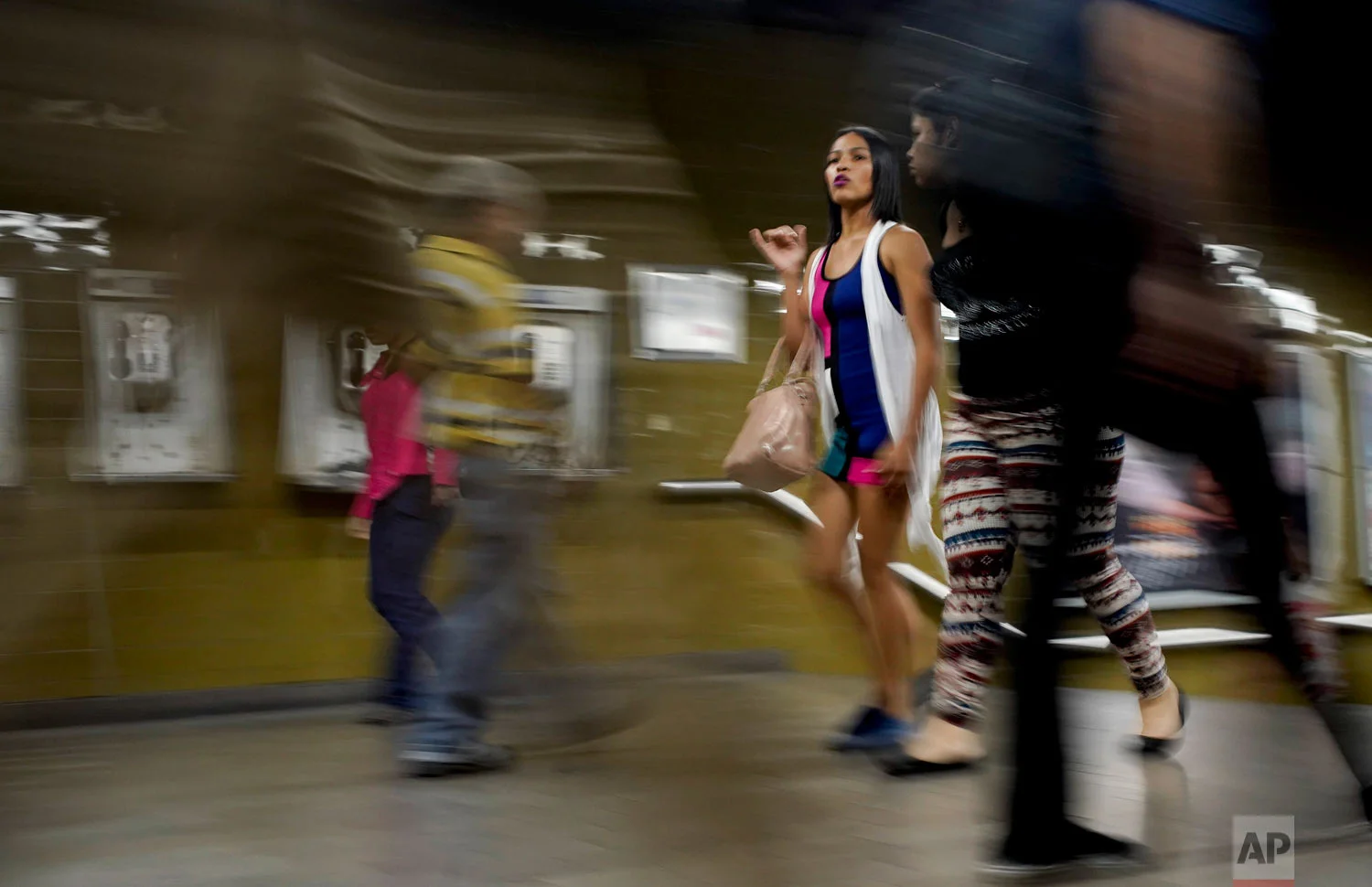  A woman wearing makeup and with her hair straightened walks through the subway in Caracas, Venezuela, Friday, March 22, 2019. (AP Photo/Natacha Pisarenko) 