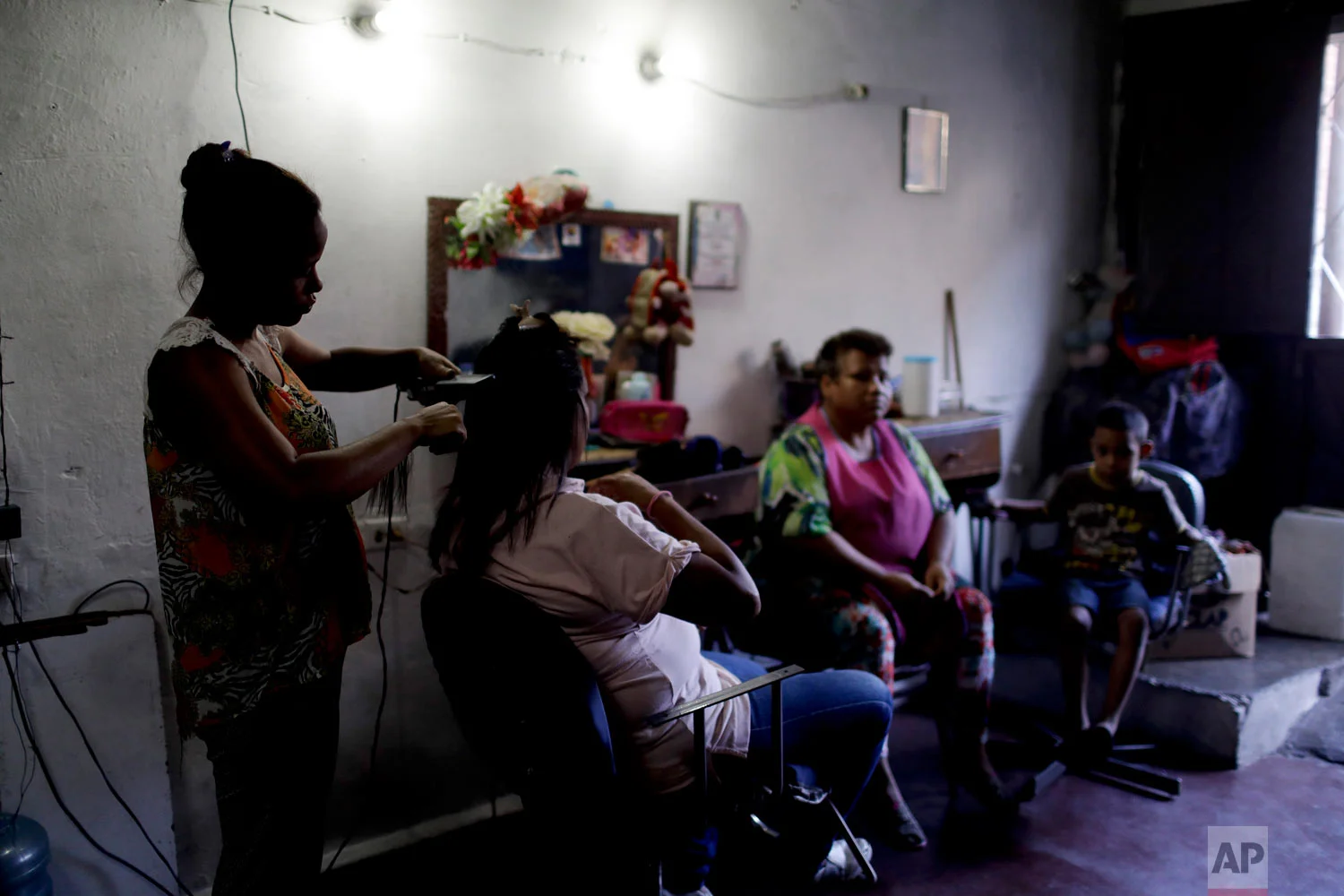  Hair dresser Rosevel Velazquez attends a customer at her beauty salon, which she runs out of her home in Caracas, Venezuela, Wednesday, March 20, 2019.  (AP Photo/Natacha Pisarenko) 