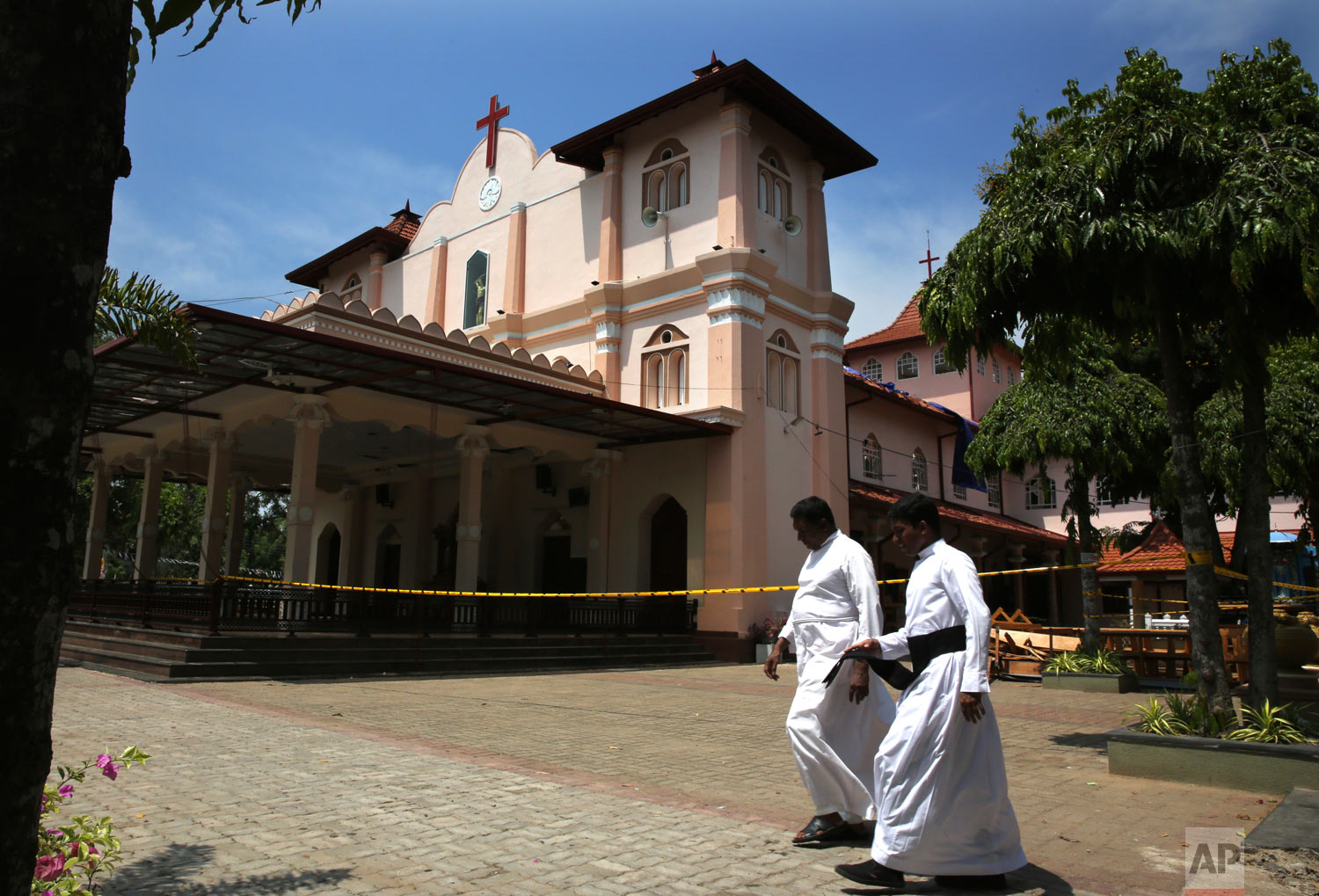 Catholic priests walk outside St. Sebastian's Church, where a suicide bomber blew himself up on Easter Sunday in Negombo, north of Colombo, Sri Lanka, April 25, 2019. (AP Photo/Manish Swarup)