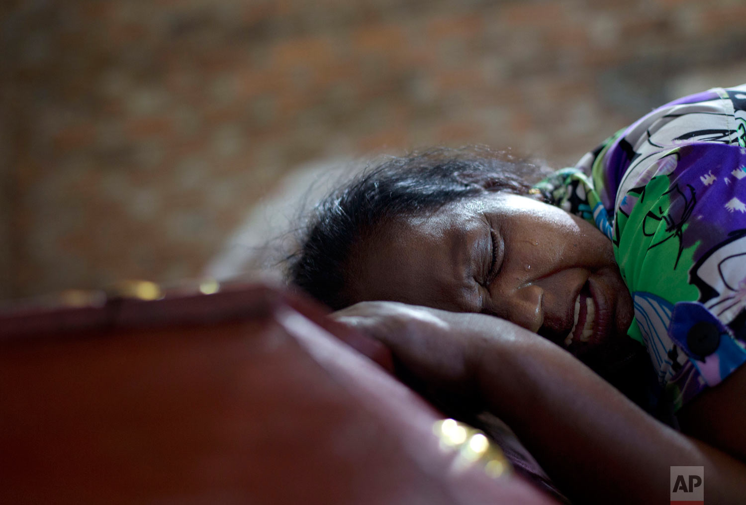 Lalitha weeps on the coffin with the remains of 12-year old niece, Sneha Savindi, who was a victim of Easter Sunday bombing at St. Sebastian Church in Negombo, Sri Lanka, April 22, 2019. (AP Photo/Gemunu Amarasinghe)
