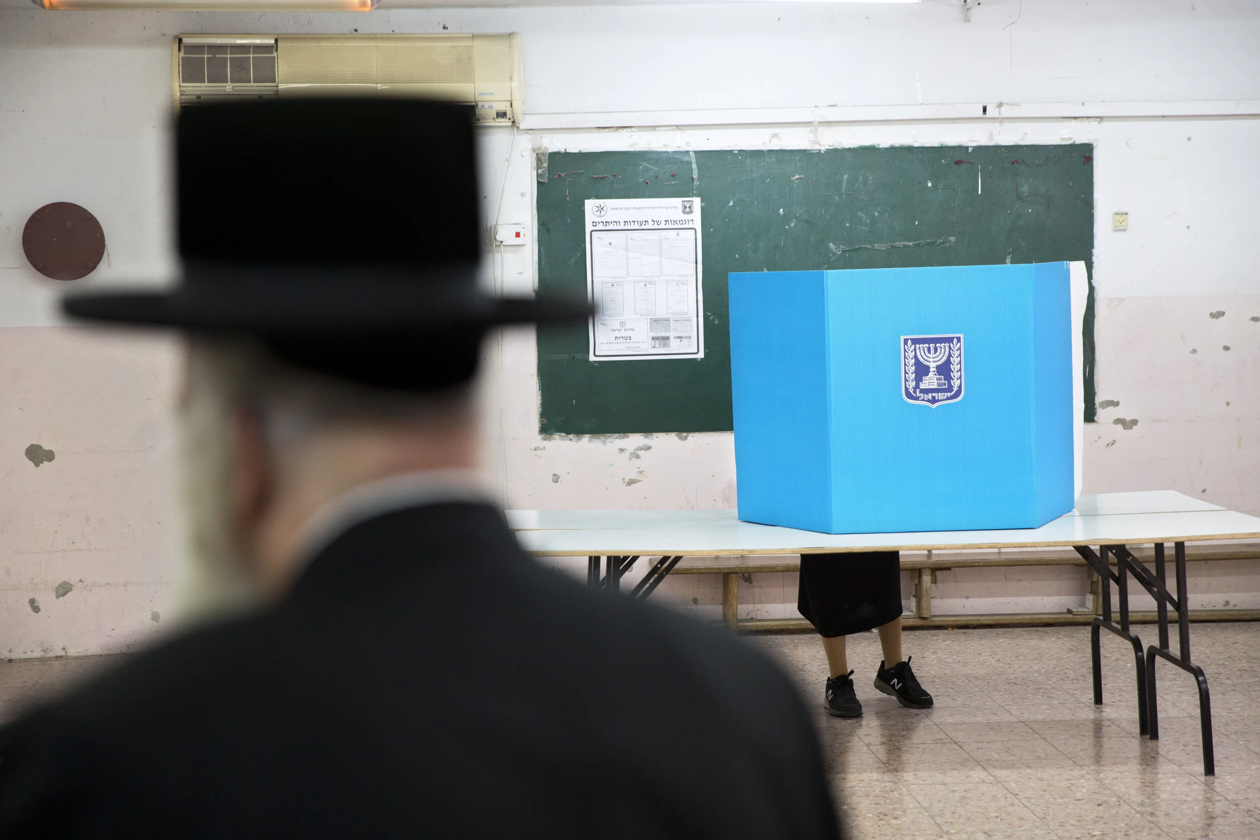 An ultra-orthodox Jewish woman votes for Israel's parliamentary election at a polling station in Bnei Brak, Israel, Tuesday, April 9, 2019. (AP Photo/Oded Balilty)