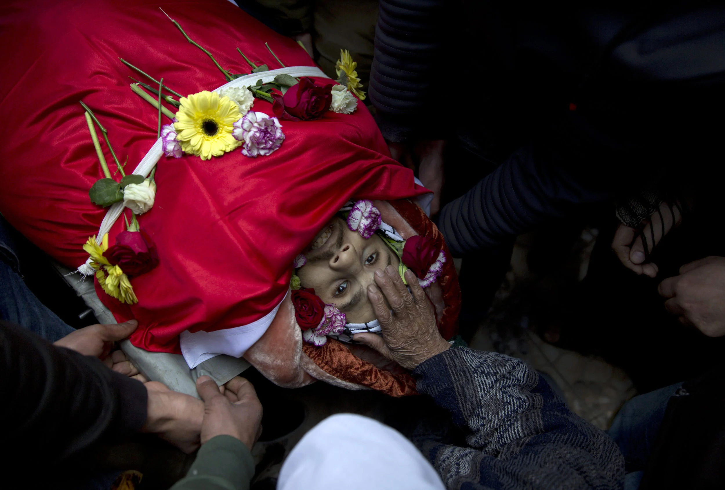 Mourners take a farewell look at the body of Mohammad Edwan, 23, who was shot and killed by Israeli troops, in the West Bank Refugee camp of Qalandia, near Ramallah, Tuesday, April 2, 2019. (AP Photo/Nasser Nasser)