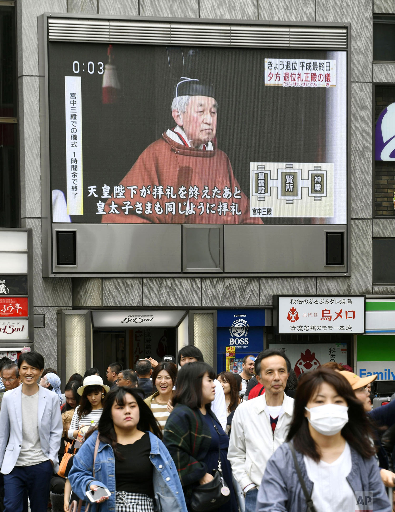  An outdoor screen displays Emperor Akihito leaving a ritual to report his abdication to the throne, shown in a news program in Osaka, western Japan, Tuesday, April 30, 2019. The 85-year-old Akihito ended his three-decade reign on Tuesday relinquishi