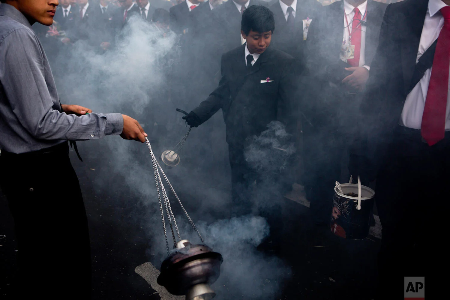 Boys swing burners with incense purifying the path of the “La Reseña,” procession known as “La Reseña” in downtown Guatemala City, April 16, 2019. (AP Photo/Moises Castillo)