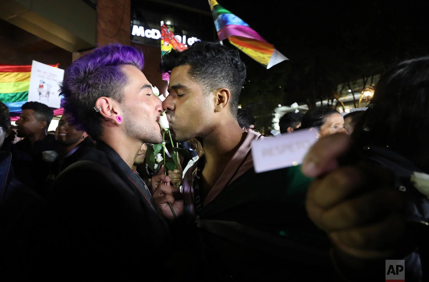 A same sex couple kiss a rose during a "Kiss-a-thon," as a form of protest for LGBT rights and against discrimination in Bogota, Colombia, April 17, 2019. (AP Photo/Fernando Vergara)