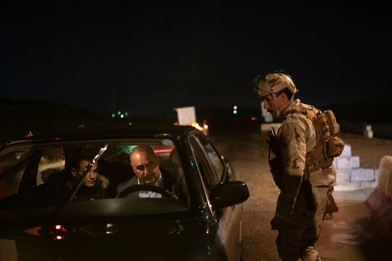 In this April 2, 2019 photo, an Iraqi army 20th division soldier asks for documents at a checkpoint near Badoush, Iraq. (AP Photo/Felipe Dana)