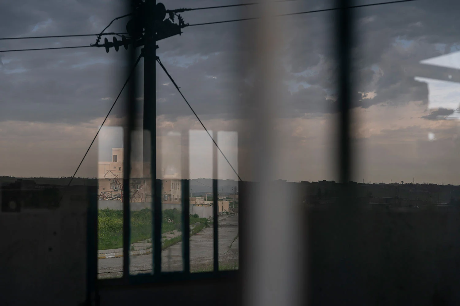 In this April 10, 2019 photo, houses are reflected on the window of an Iraqi army base in Badoush, Iraq. (AP Photo/Felipe Dana)