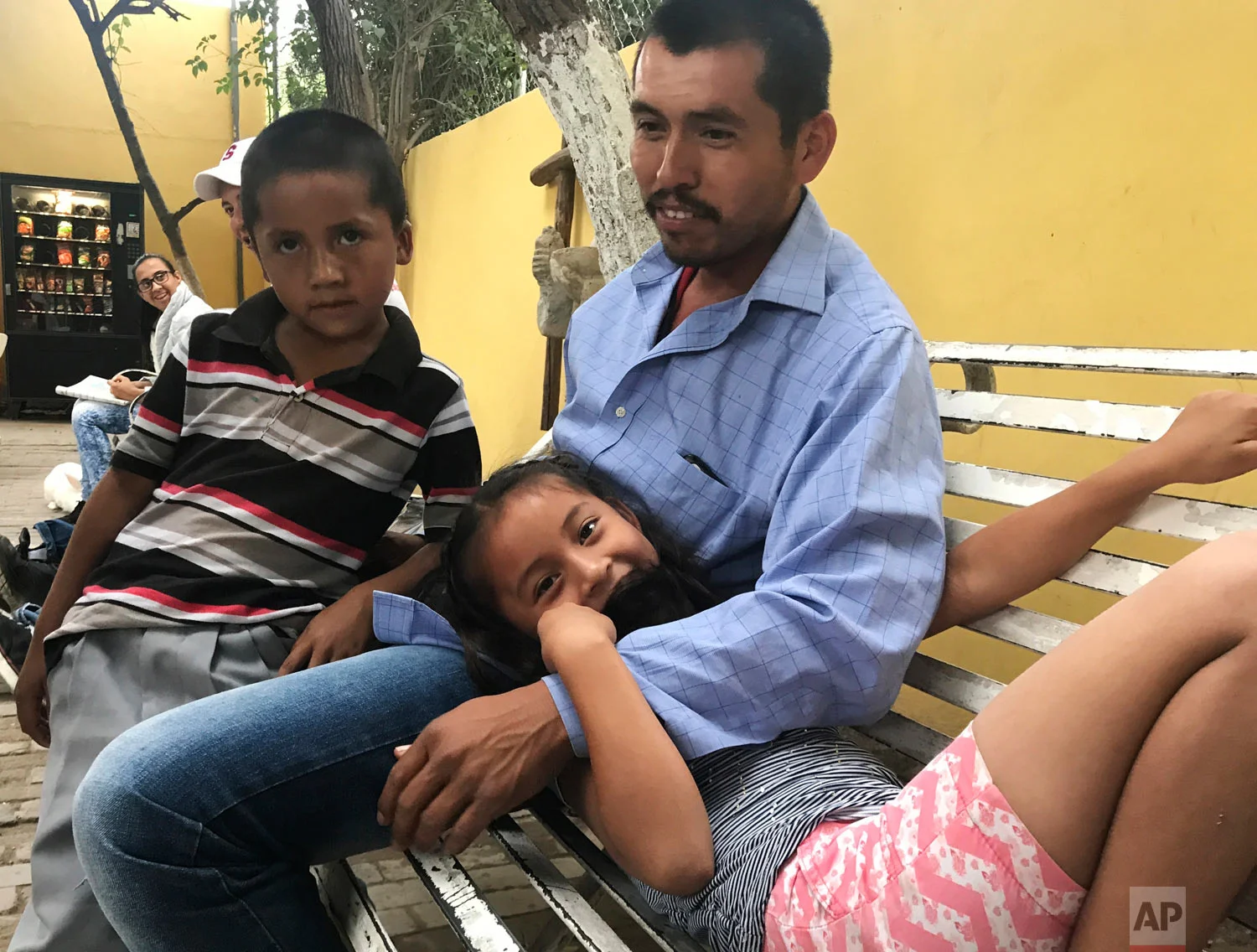 A father waits with his daughter and son in Piedras Negras, Mexico, as they seek asylum in the U.S., March 27, 2019. (AP Photo/Nomaan Merchant)