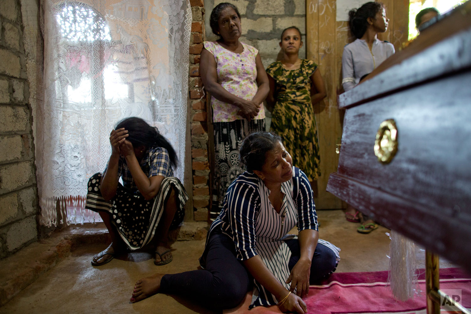 Relatives weep at the coffin with the remains of 12-year Sneha Savindi, who was a victim of Easter Sunday bomb blast at St. Sebastian Church reach home, Monday, April 22, 2019 in Negombo, Sri Lanka. The Easter Sunday bombings of churches, luxury hotels and other sites was Sri Lanka's deadliest violence since a devastating civil war in the South Asian island nation ended a decade ago. (AP Photo/Gemunu Amarasinghe)