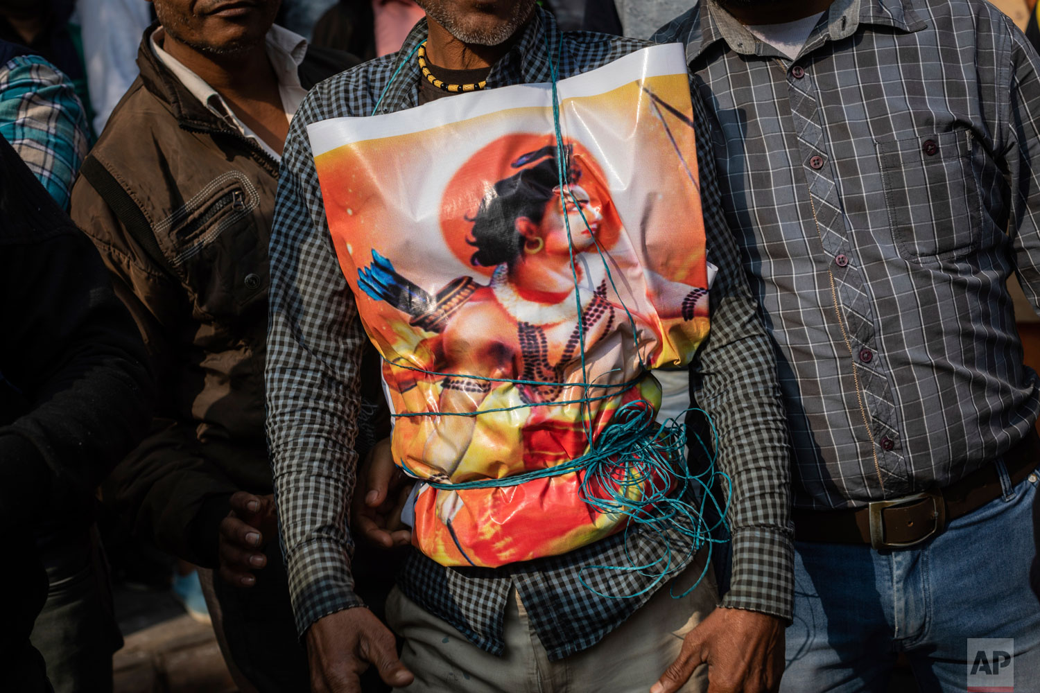 In this Sunday, Dec. 9, 2018 photo, a supporter of Hindu-extreme political group Vishwa Hindu Parishad wears a poster of the Hindu god Ram during a rally in New Delhi, India. (AP Photo/Bernat Armangue)