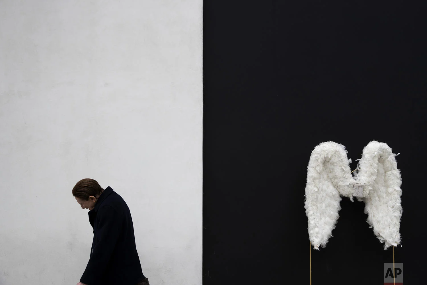 A man walks by a pair of angel wings as part of a store display in Beverly Hills, Calif., on Tuesday, May 7, 2019 (AP Photo/Jae C. Hong)