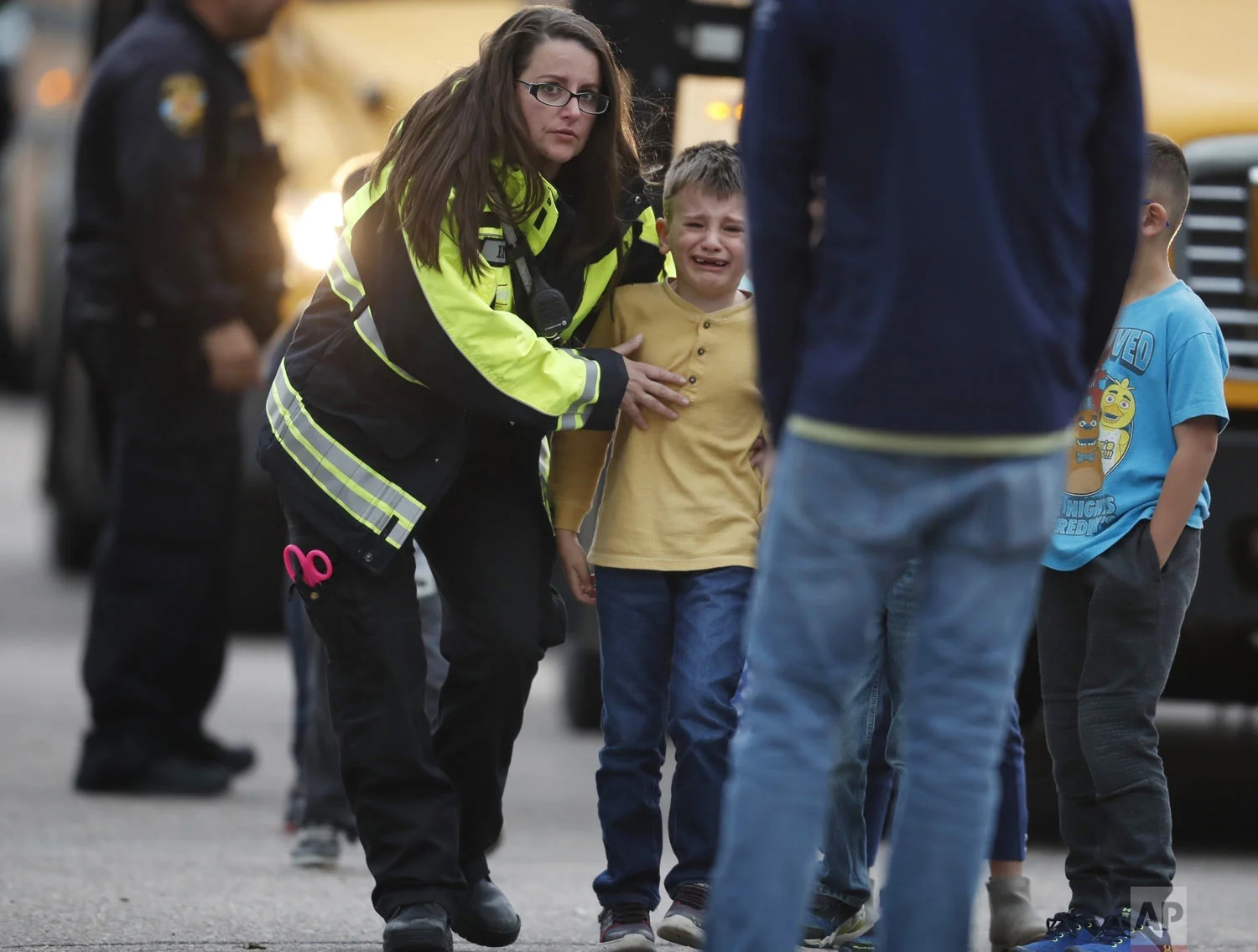Officials guide students off a bus and into a recreation center where they were reunited with their parents after a shooting at a suburban Denver middle school Tuesday, May 7, 2019, in Highlands Ranch, Colo. (AP Photo/David Zalubowski)