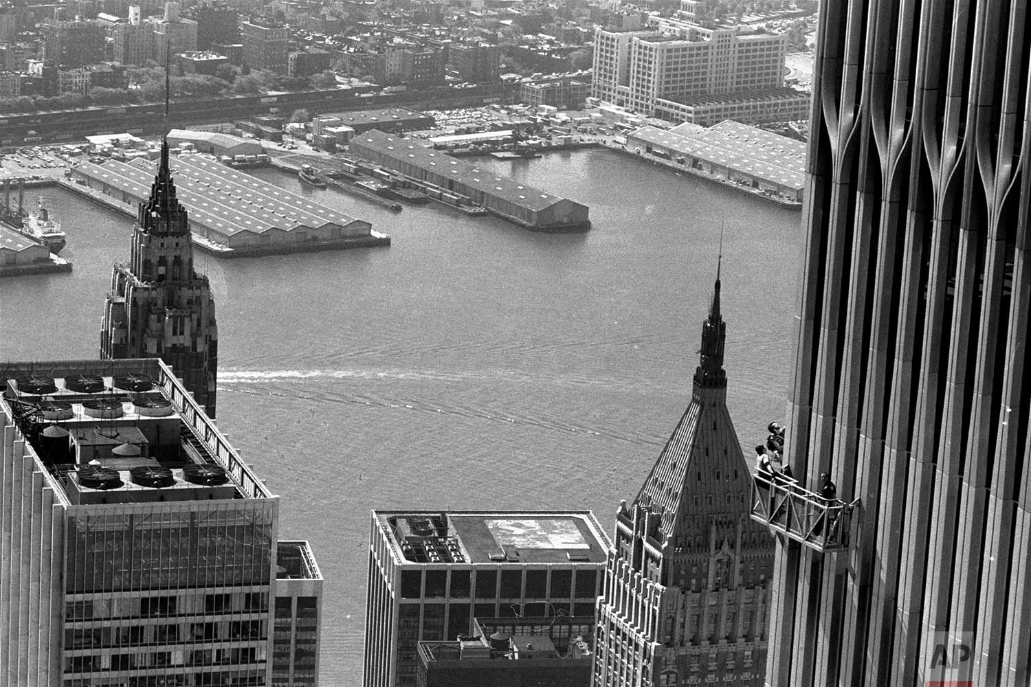 This view from the top of the north tower of the World Trade Center Thursday, May 26, 1977, shows climber George Willig, and accompanying police on the window washing apparatus, inching up the south tower, right. This view looks toward the East River with Brooklyn in background. (AP Photo/Dave Pickoff)