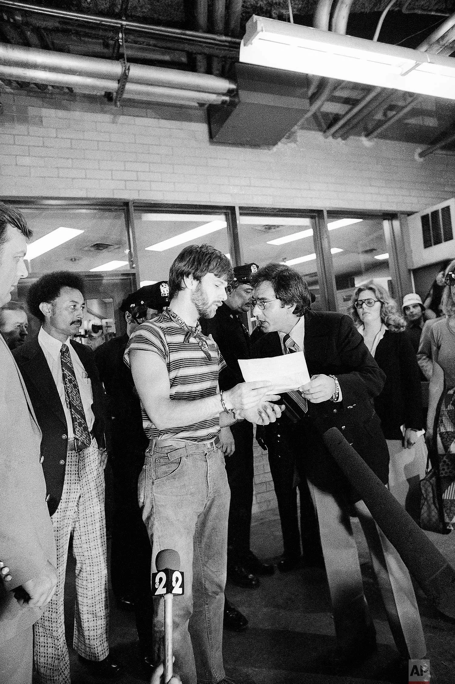 Daredevil George Willig is shown after he left the police station inside the World Trade Center, with newsmen around him in New York, May 26, 1977. Willig scaled one of the Twin Towers and was arrested upon finishing his ascent. (AP Photo/Carlos Rene Perez)