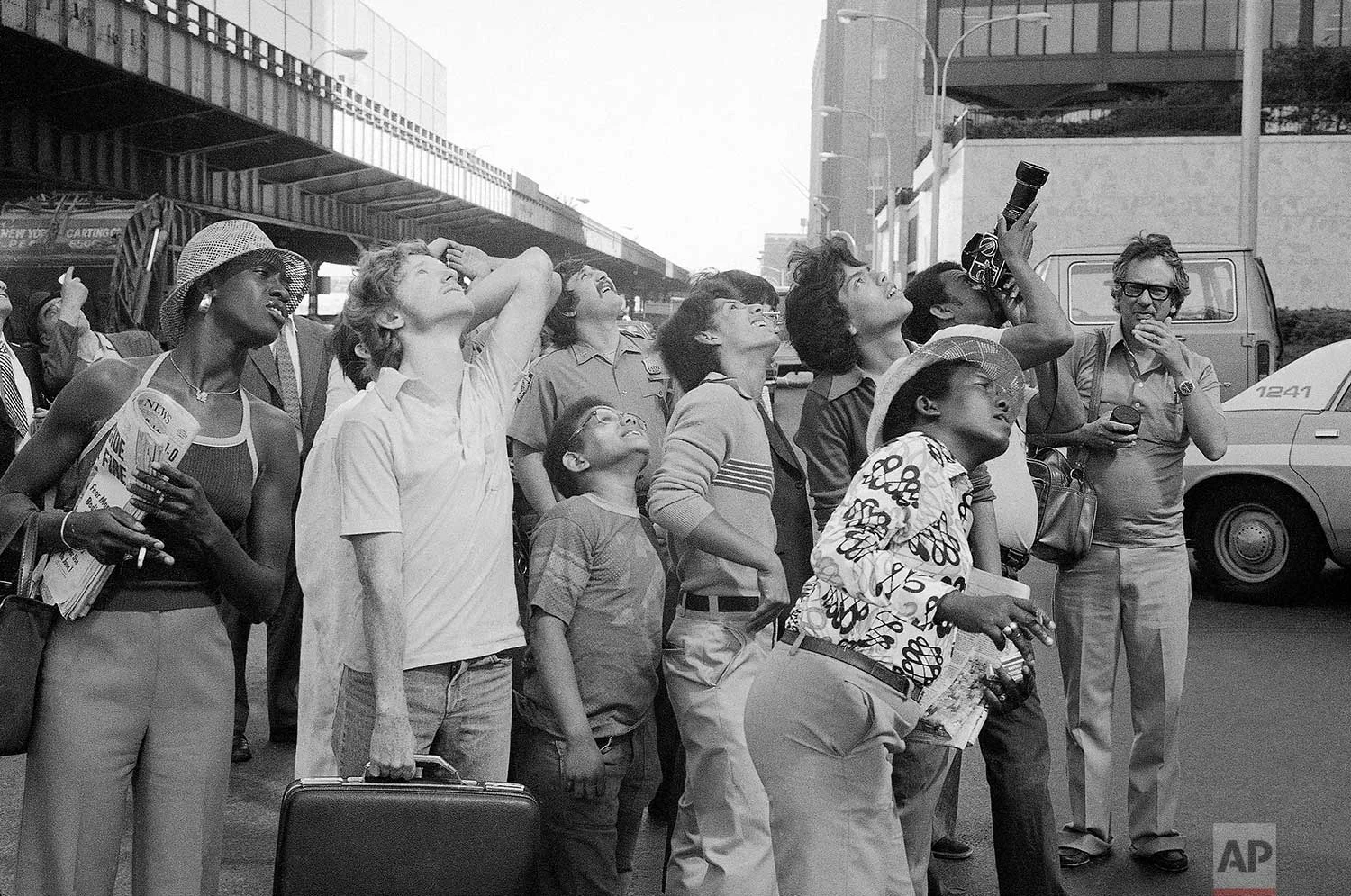 People watch George Willig, aerial daredevil, ascend the base of the World Trade Center in New York, May 26, 1977. (AP Photo/Carlos Rene Perez)