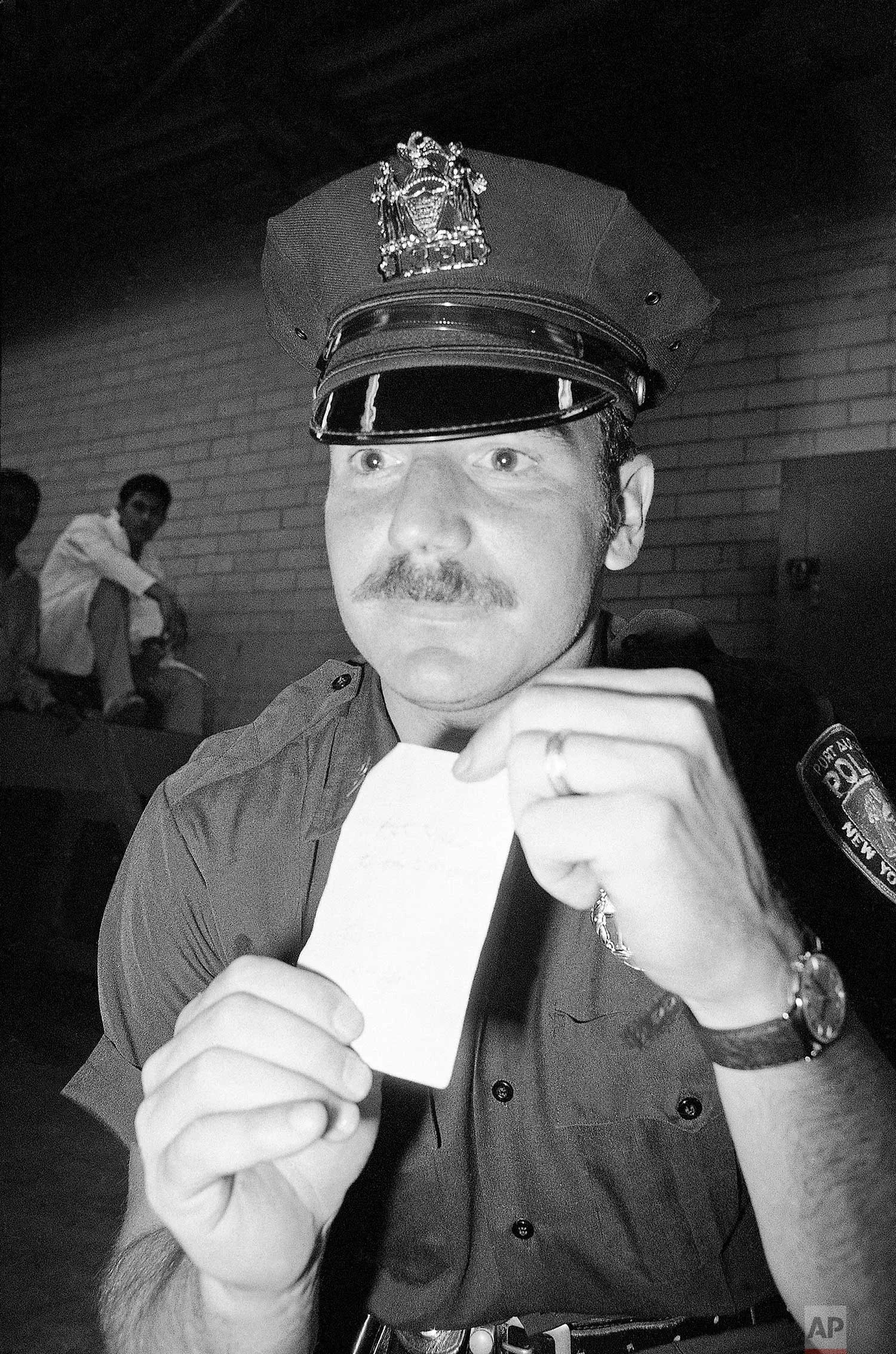 Officer Glenn Kildare with an autograph he received from George Willig in New York, May 26, 1977. (AP Photo/Carlos Rene Perez)