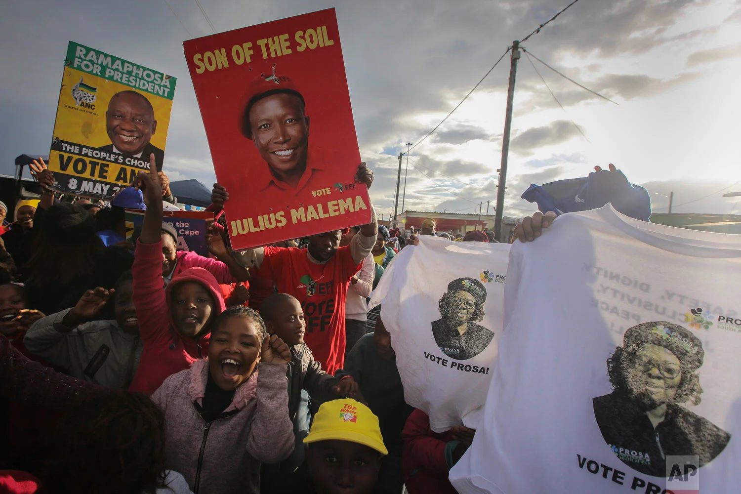 African National Congress (ANC) supporters, with green and yellow posters celebrate alongside rival Economic Freedom Fighters, (EFF) red posters, outside a voting station in Khayelitsha Township, Cape Town, South Africa, May 8, 2019. (AP Photo/Halden Krog)