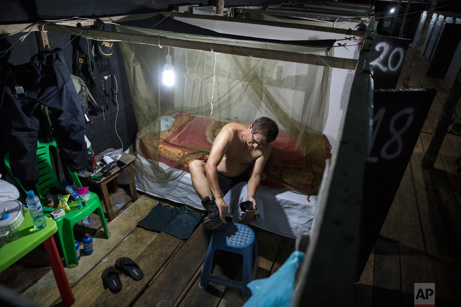 Police officer Julio Garcia polishes his boots inside a dwelling once used by illegal miners, now known as part of the Balata military and police base on March 31, 2019, in Peru’s Tambopata province. (AP Photo/Rodrigo Abd)