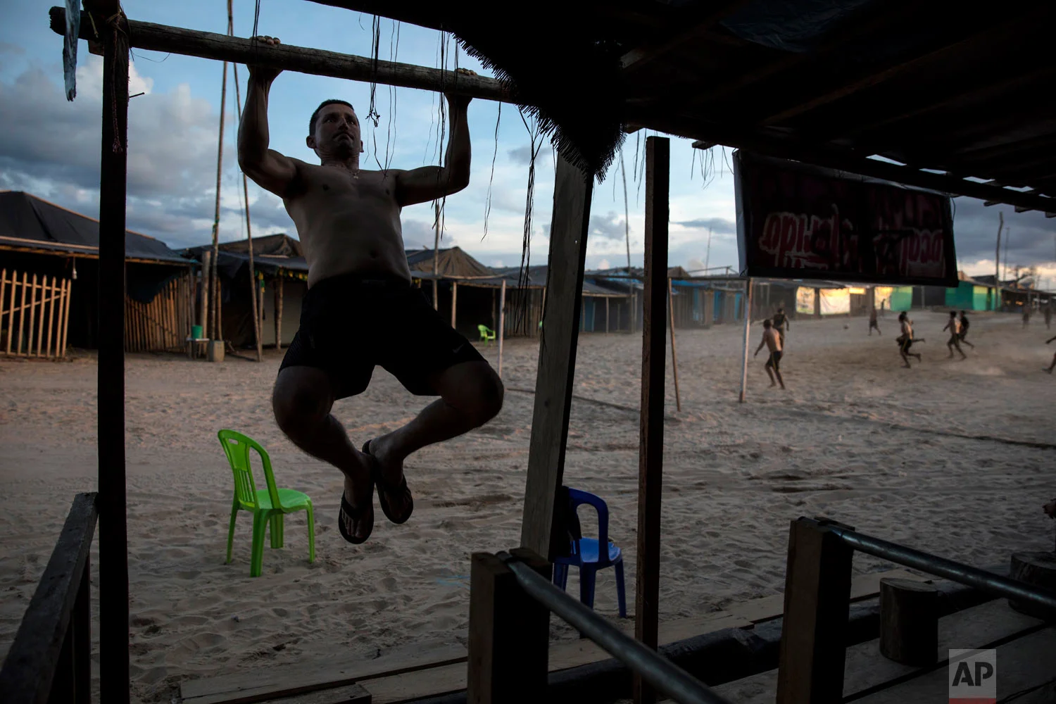 Maj. Gustavo Cerdeña does pull-ups using the wood frame of a structure at the Balata police and military base, once an illegal gold mining camp, March 31, 2019, in Peru’s Tambopata province. Cerdeña said he had come to the booming area before the start of "Operation Mercury", in February. "It was full of people, it was like Gomorrah before it rained fire," he said, referring to the notorious city's destruction in the Bible. "Now everything is quieter." (AP Photo/Rodrigo Abd)