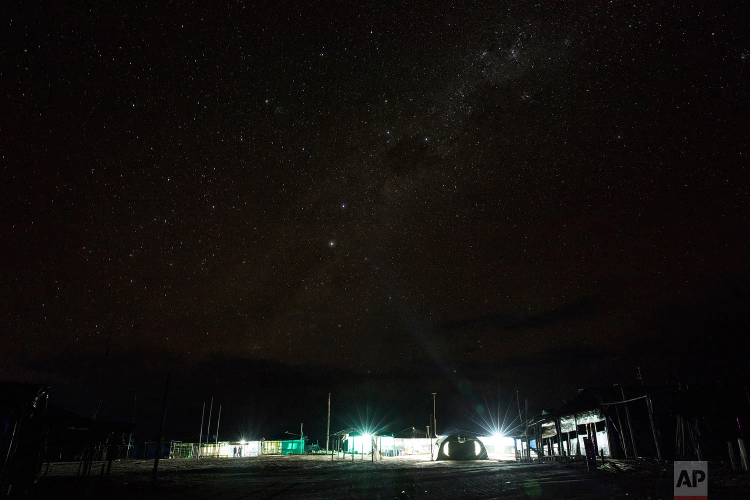 A night view of the Balata police and military base is seen March 31, 2019, at the Balata police and military base, illuminated by electric generators, in Peru's Tambopata province. The area known by miners as "La Pampa," which surrounds a national park and doesn't appear on state maps, has yielded roughly 25 tons of illegally mined gold a year, much more than the legally produced amount in the same area, according to the Peruvian government. (AP Photo/Rodrigo Abd)