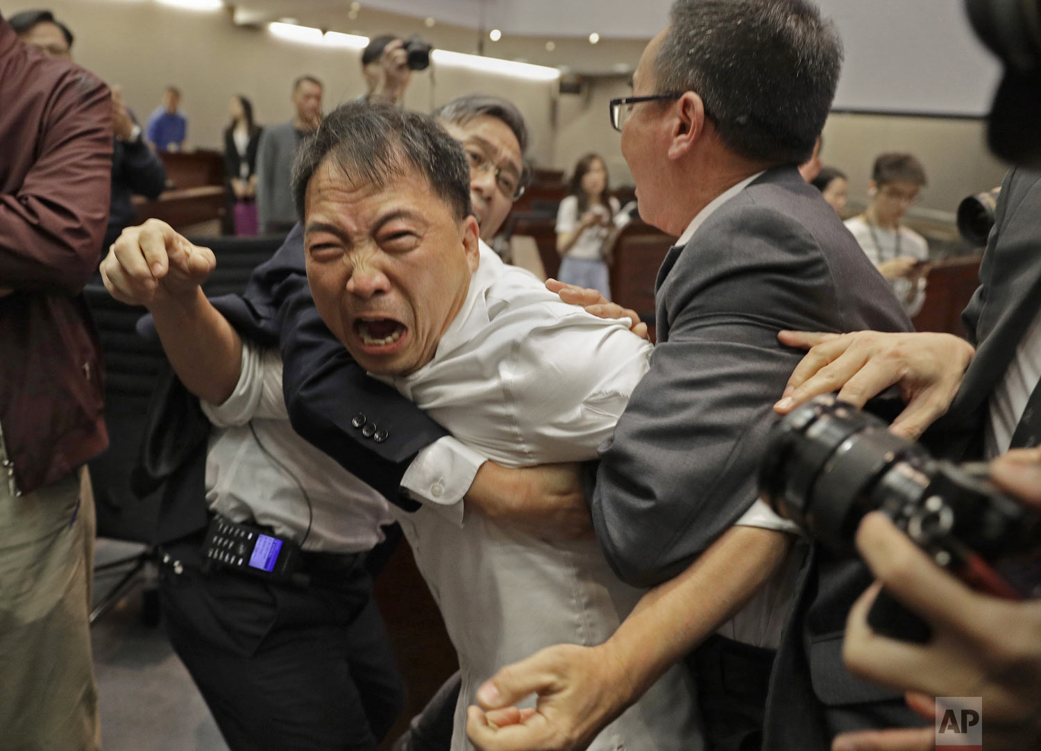  Pro-democracy lawmaker Wu Chi-wai, center, is restrained by security guards at the Legislative Council in Hong Kong, Saturday, May 11, 2019. Hong Kong's legislative assembly descended into chaos Saturday as lawmakers for and against controversial am