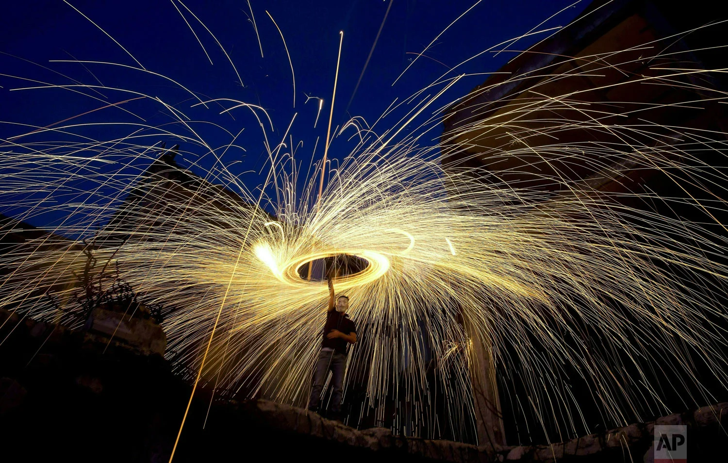 People light fireworks above the rubble of destroyed buildings to celebrate the holy month of Ramadan in Gaza City, Monday, May 13, 2019. Muslims around the world are observing Ramadan, the holiest month in Islamic calendar. (AP Photo/Hatem Moussa)
