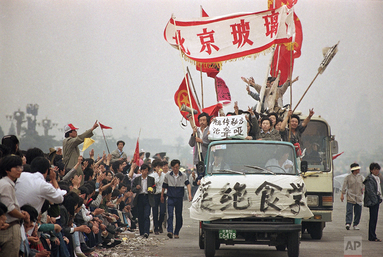  Enthusiastic demonstrators are cheered by bystanders as they arrive at Tiananmen Square to show support for the student hunger strike, Thursday, May 18, 1989, Beijing, China. Students are striking for government reforms. (AP Photo/Sadayuki Mikami) 