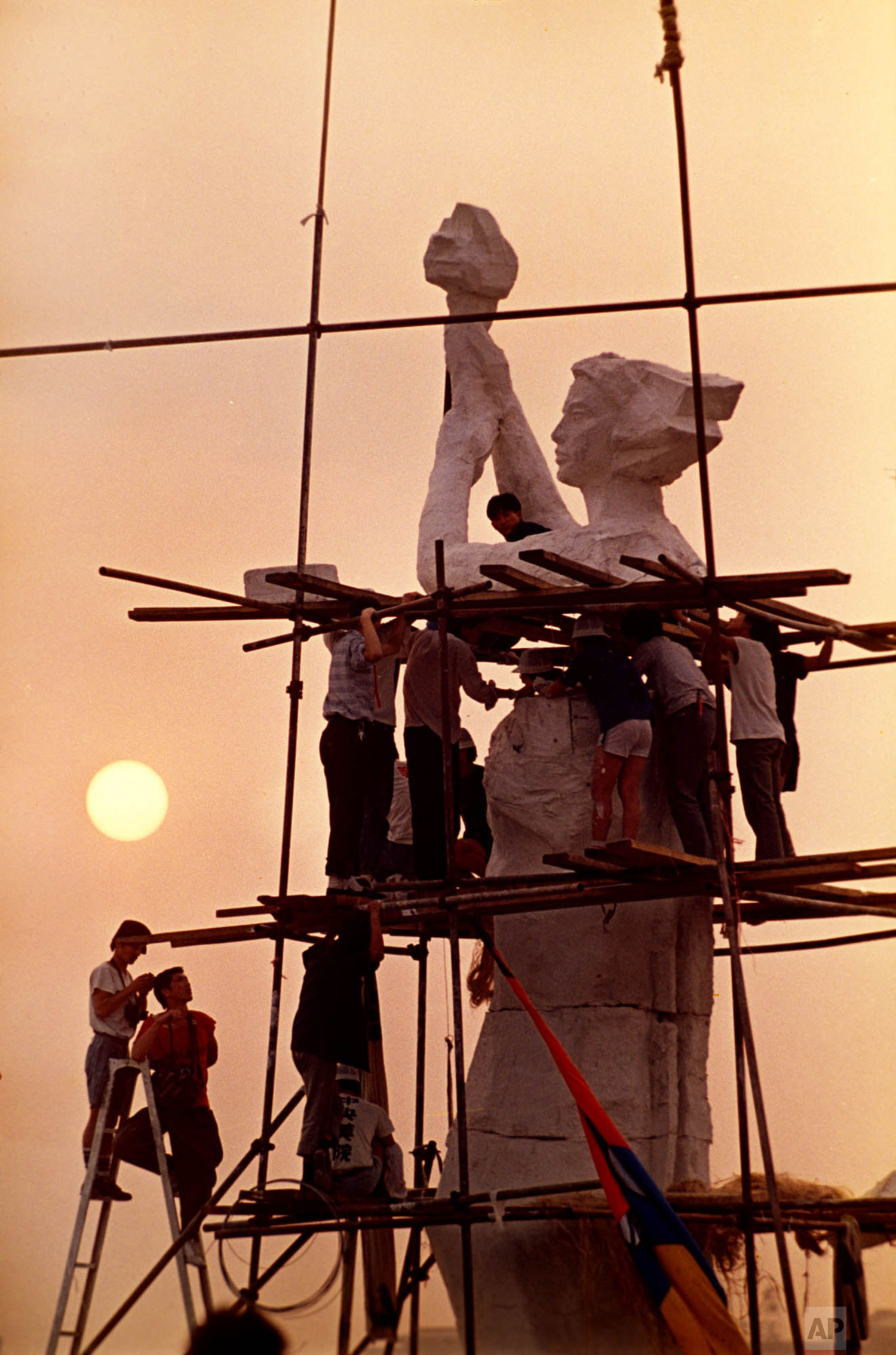  Protesters occupying Beijing's Tiananmen Square work on the statue of the Goddess of Democracy, May 30, 1989. The makeshift statue, modeled after the Statue of Liberty, was destroyed, and hundreds of people killed, when Chinese soldiers overran the 