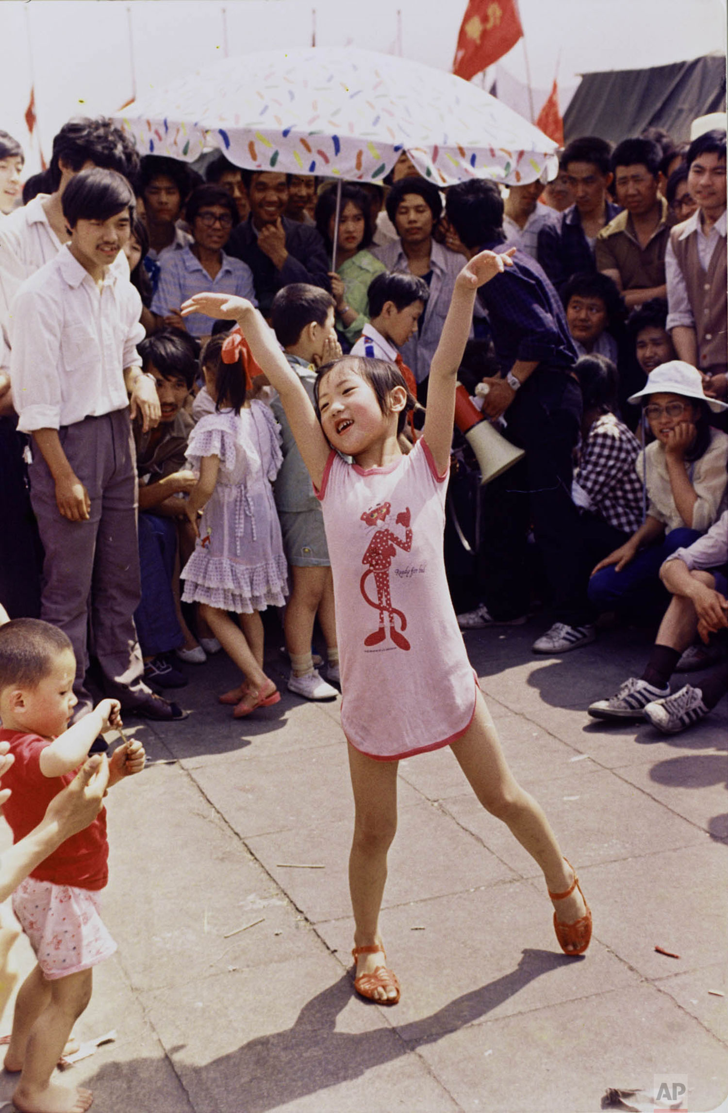  A young Chinese girl dances on Tiananmen Square about June 1, 1989, as pro-democracy protesters continued to occupy the square. Hundreds were killed a few days later in violent clashes between the demonstrators and government troops. (AP Photo/Jeff 
