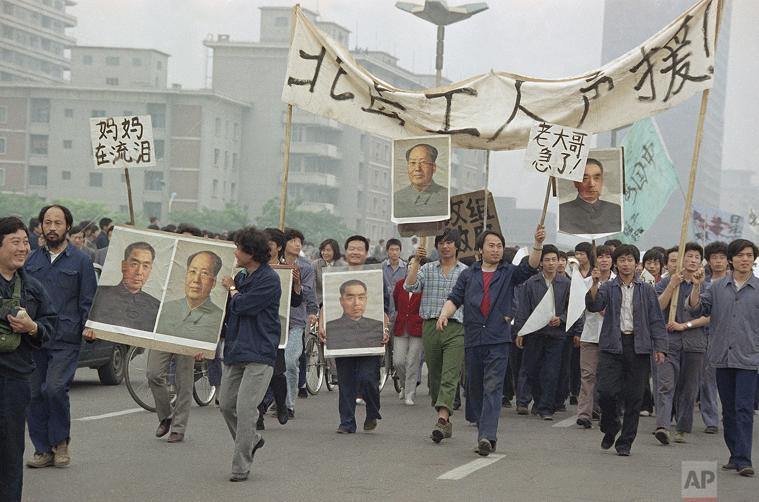  Pro Democracy demonstrators carry portraits of former Chinese rulers Mao Tse-Tung and Chou En-Lai as they march to join student strikers at Tiananmen Square, May 18, 1989, Beijing, China. (AP Photo/Sadayuki Mikami) 