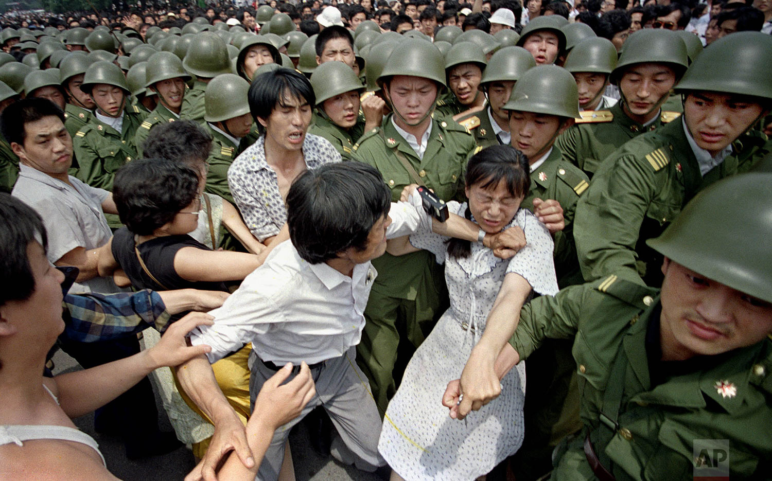  A young woman is caught between civilians and Chinese soldiers, who were trying to remove her from an assembly near the Great Hall of the People in Beijing, June 3, 1989. Pro-democracy protesters had been occupying Tiananmen Square for weeks. (AP Ph