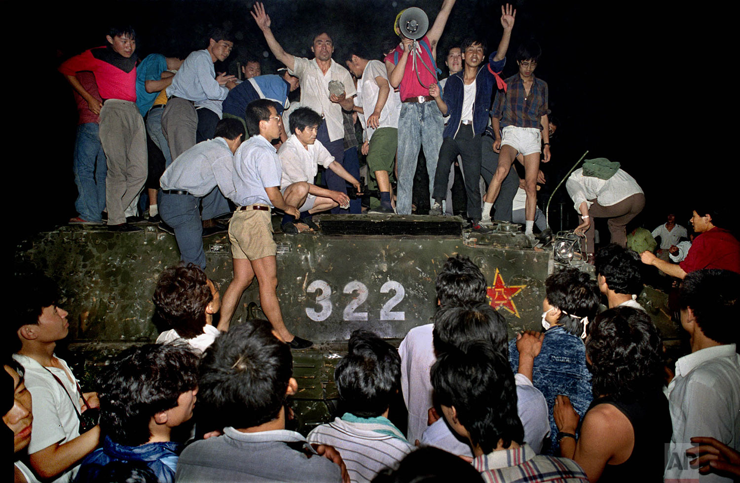  In this early June 4, 1989 file photo, civilians with rocks stand on a government armored vehicle near Chang'an Boulevard in Beijing as violence escalated between pro-democracy protesters and Chinese troops, leaving hundreds dead overnight. The lega