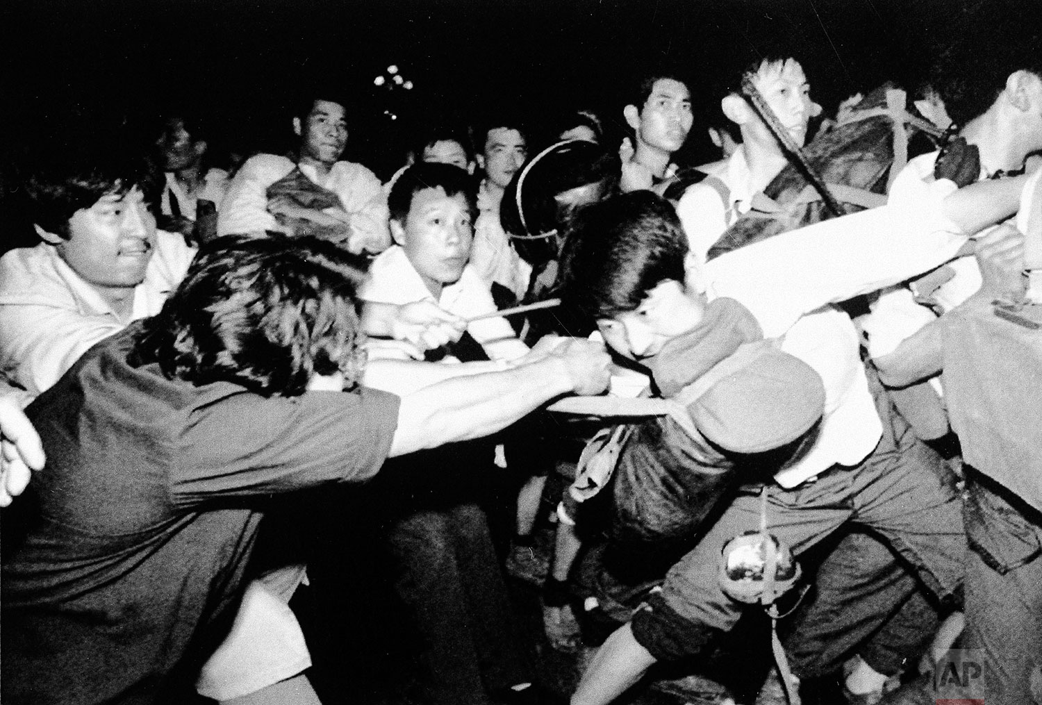  A man tries to pull a Chinese soldier away from his comrades as thousands of Beijing's citizens turned out to block thousands of troops on their way towards Tiananmen Square early Saturday morning, June 3, 1989. (AP Photo/Mark Avery) 