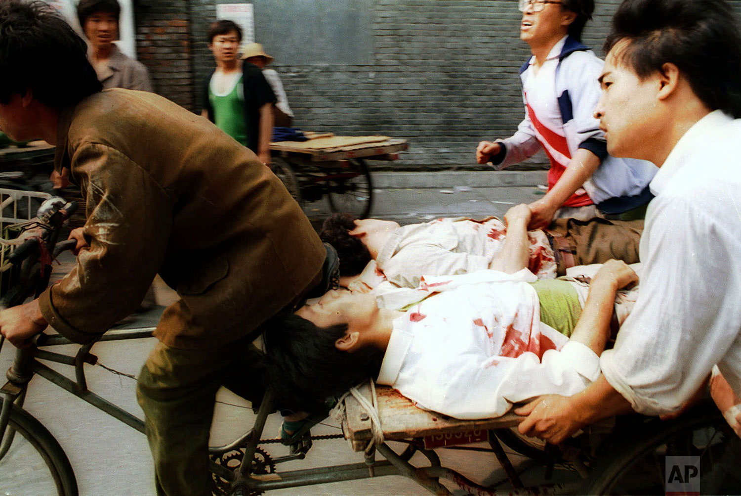  WARNING: GRAPHIC CONTENT  A rickshaw driver fiercely peddles the wounded people, with the help of bystanders, to a nearby hospital Sunday, June 4, 1989. PLA soldiers again fired hundreds of rounds towards angry crowds gathered outside Tiananmen Squa