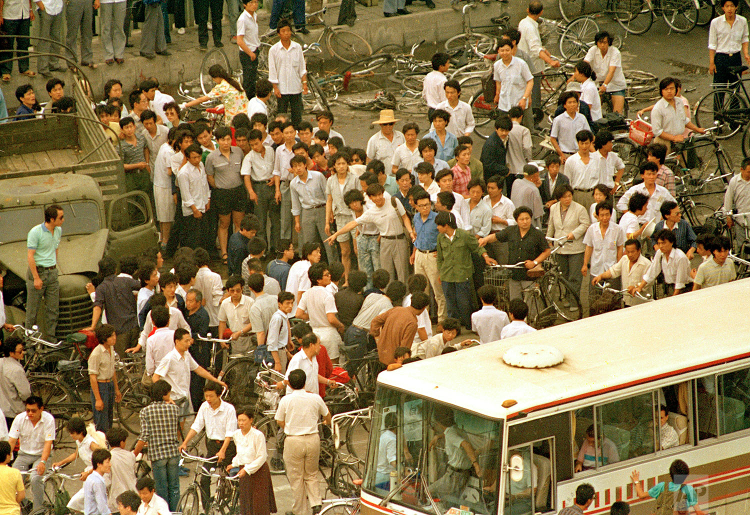  A crowd of Chinese opens hole to give a busload of foreign tourists a view of a dead body Monday morning, June 5, 1989, of victim of the first night of violence as People's Liberation Army troops shot their way into Tiananmen Square to crush pro-dem