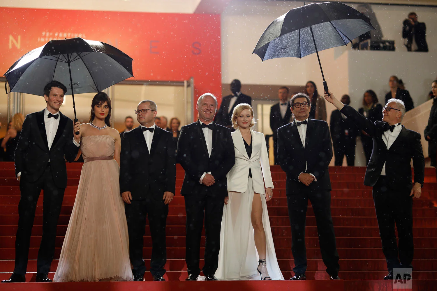 Actors Sabin Tambrea, Catrinel Marlon, director Corneliu Porumboiu, actors Vlad Ivanov, Rodica Lazar, Agusti Villaronga and Cannes film festival president Thierry Fremaux pose for photographers upon arrival at the premiere of the film 'The Whistlers' at the 72nd international film festival, Cannes, southern France, May 18, 2019. (AP Photo/Petros Giannakouris)