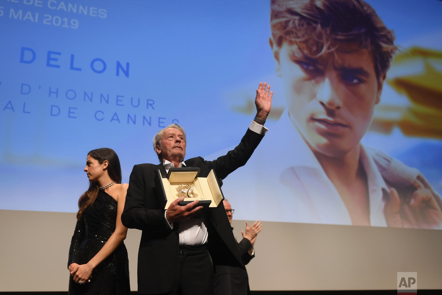 Alain Delon, centre, holds his honorary Palme D'Or award at the 72nd international film festival, Cannes, southern France, May 19, 2019. (Photo by Arthur Mola/Invision/AP)