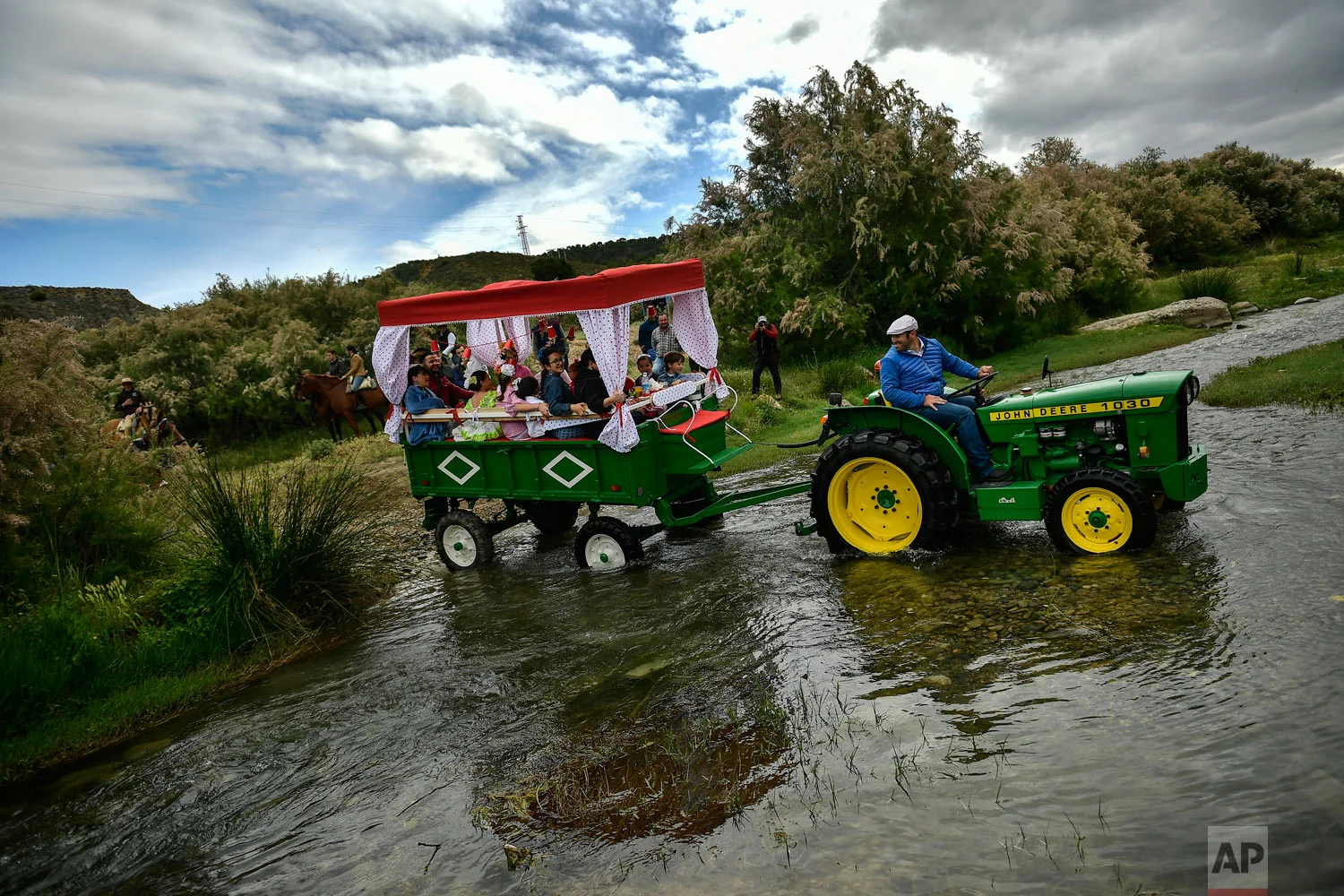 Devotees of the Rocio Virgin cross a river as they take part in the "Romeria de El Rocio" in the countryside outside Fitero, northern Spain, May 25, 2019. (AP Photo/Alvaro Barrientos)