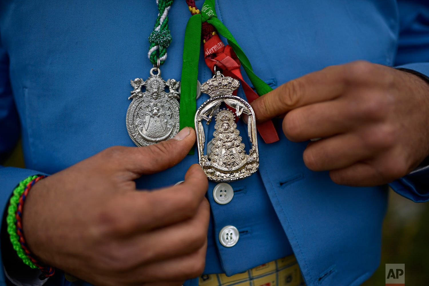 Alberto Simon shows a medallion with the image of the Virgin while taking part in the "Romeria de El Rocio" outside Fitero, northern Spain, May 25, 2019. (AP Photo/Alvaro Barrientos)