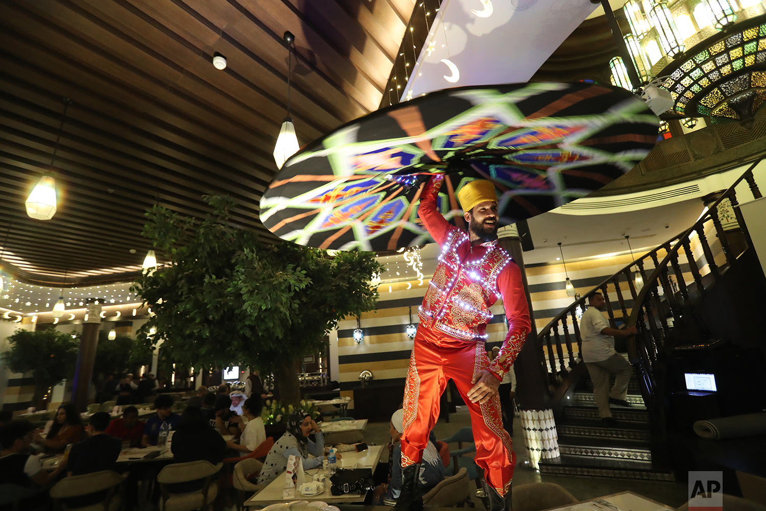  In this Wednesday, May 8, 2019 photo, Egyptian Tanoura dancer, Mustafa Borsho, performs at a restaurant located in Souq Waqif in Doha, Qatar. (AP Photo/Kamran Jebreili) 