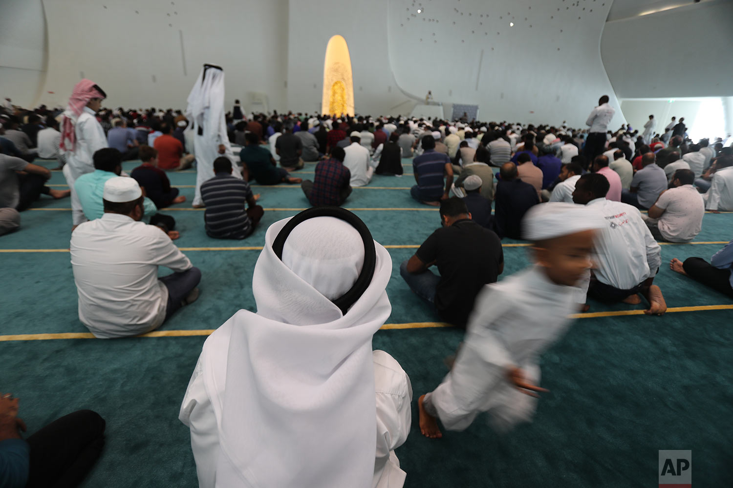  In this Friday, April 26, 2019 photo, a boy runs between the people while they are listening to the Imam during the Friday Prayers ceremony at the Qatar Faculty of Islamic Studies's mosque in Doha, Qatar. (AP Photo/Kamran Jebreili) 