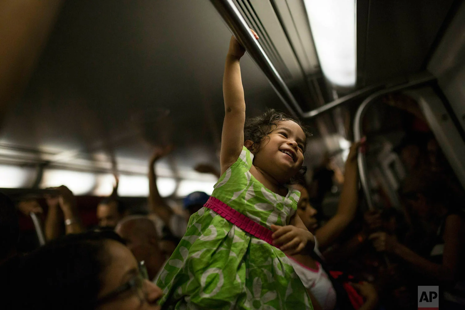 A girl plays while commuting with her mother in the subway in Caracas, Venezuela, Friday, May 10, 2019. (AP Photo/Rodrigo Abd)
