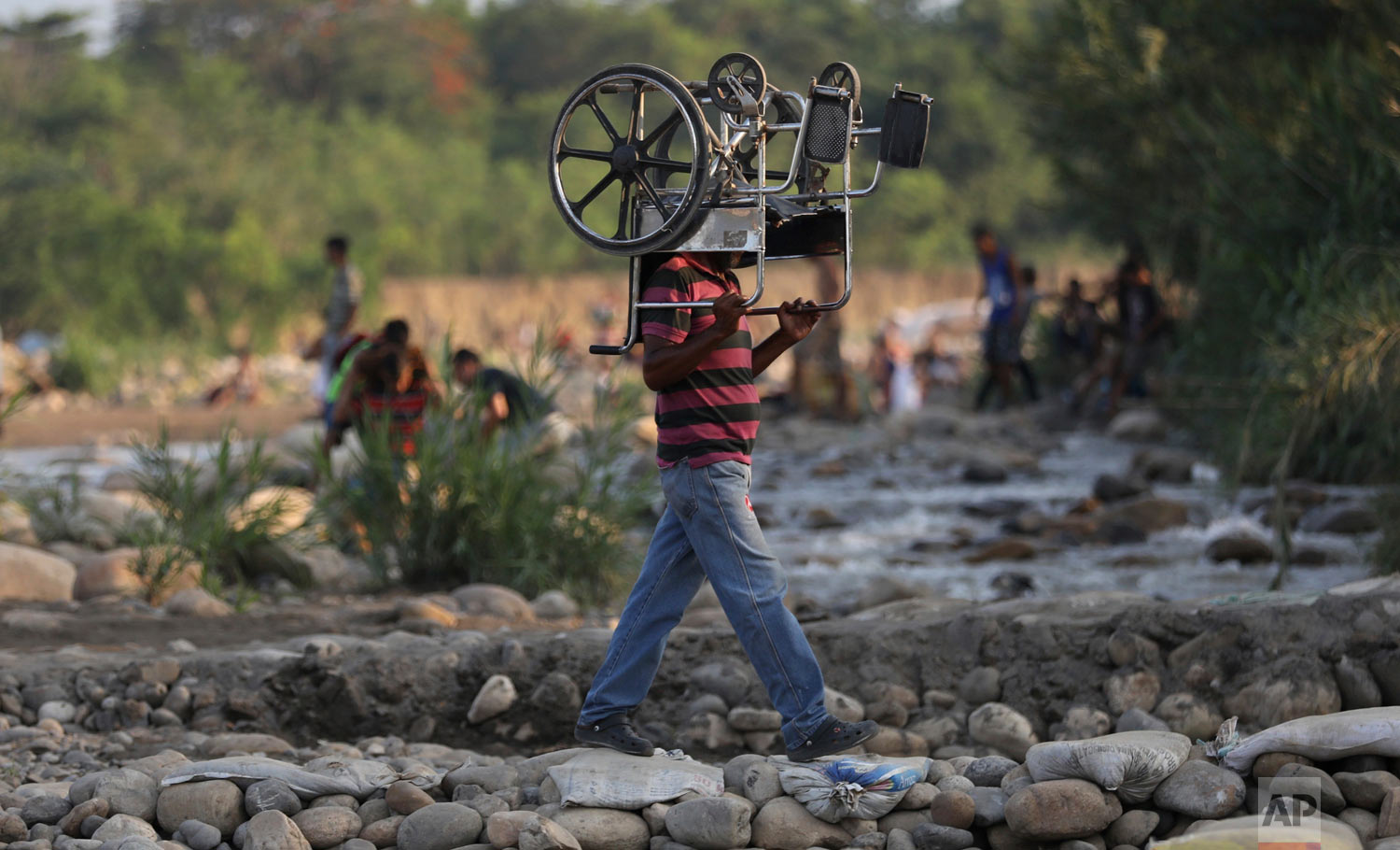  A man carries a wheelchair as he crosses illegally into Colombia from Venezuela, near the Simon Bolivar International Bridge in La Parada near Cucuta, Colombia, Wednesday, May 1, 2019. (AP Photo/Fernando Vergara) 