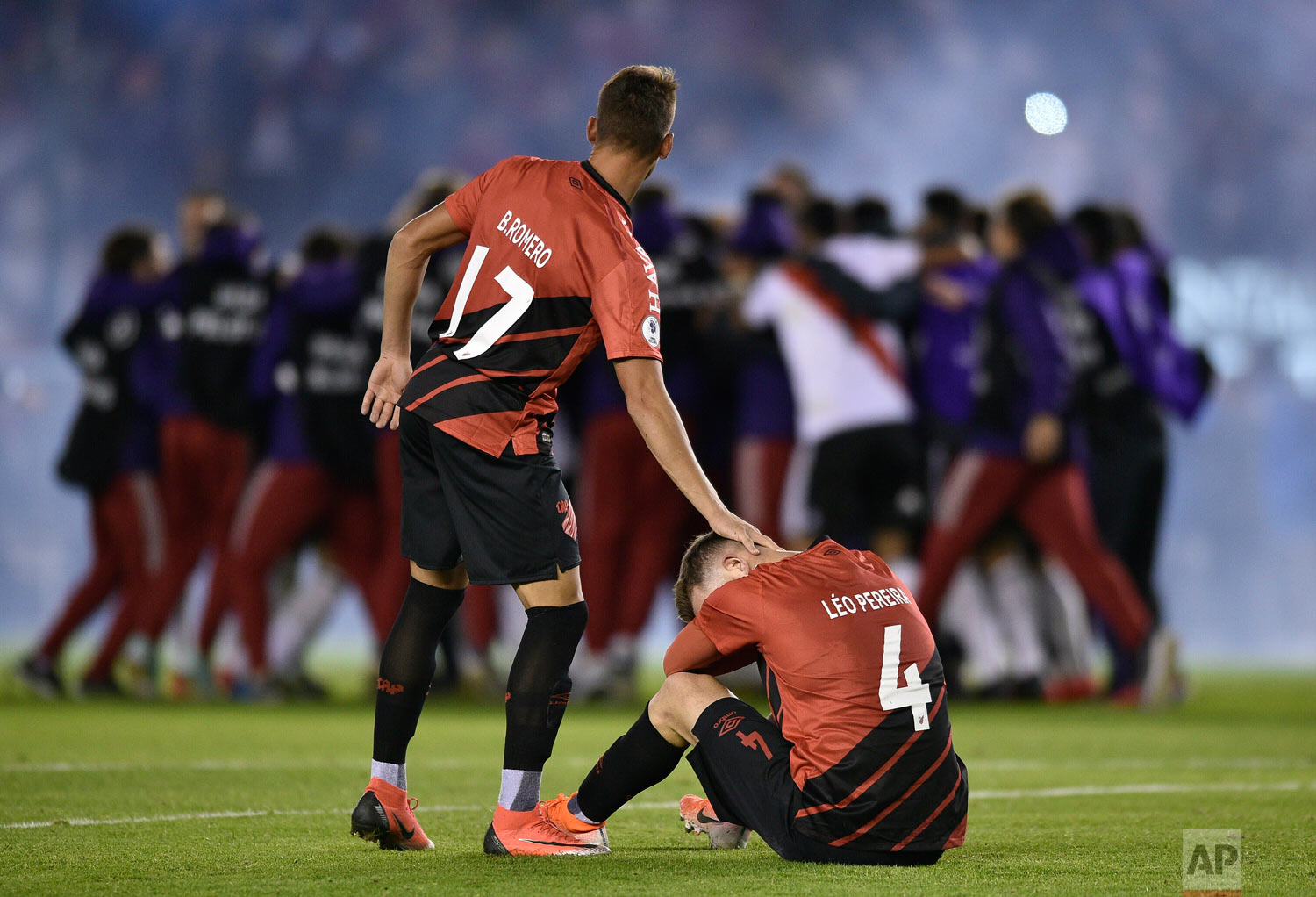  Leo Pereira of Brazil's Athletico Paranaense sits on the field as teammate Braian Romero pats him on the head after they lost the Recopa Sudamericana final 3-0 to Argentina's River Plate in Buenos Aires, Argentina, Thursday, May 30, 2019. (AP Photo/