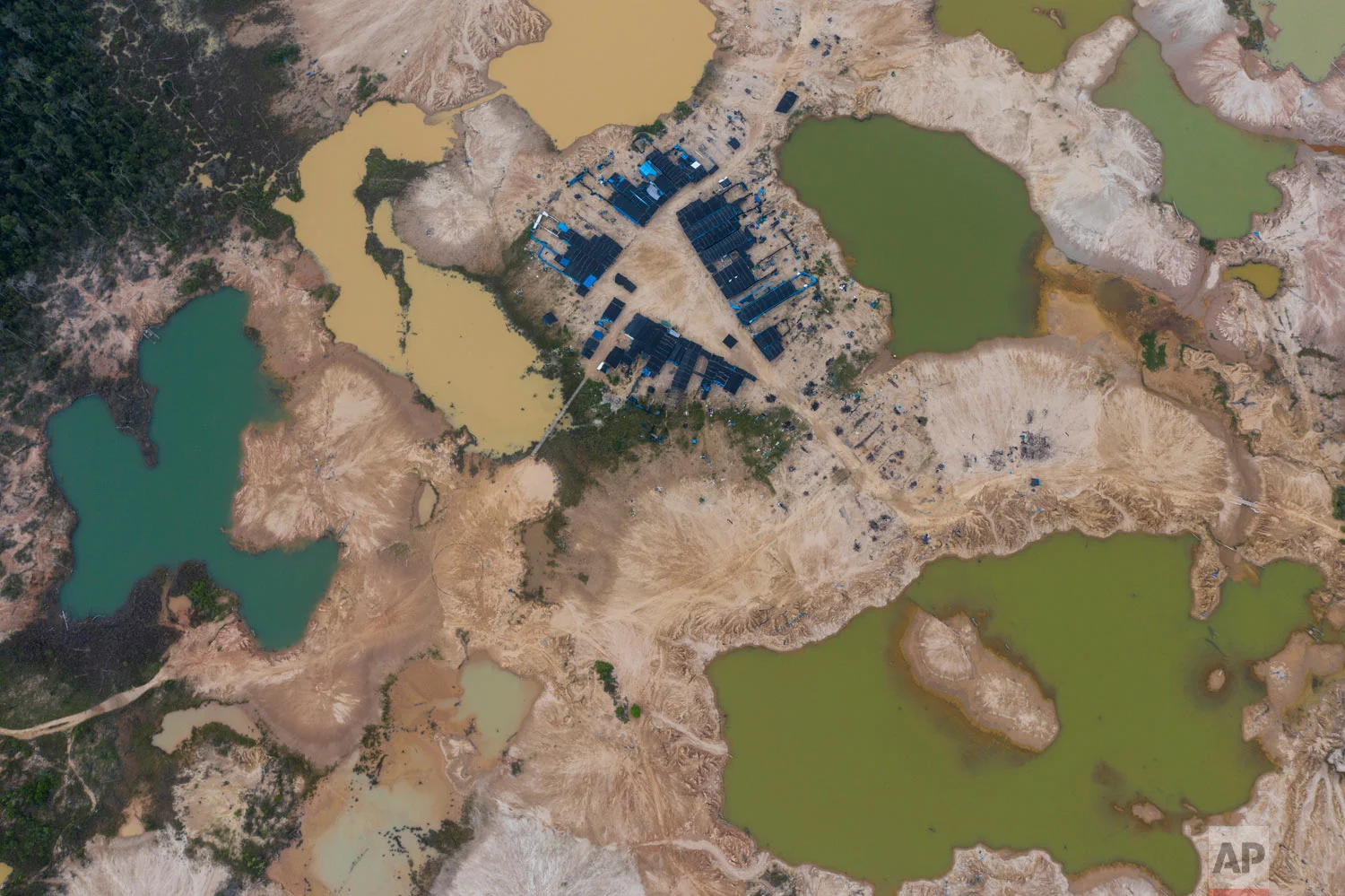 This April 3, 2019 photo published in May shows an aerial view of the Mega 12 police and military base in Peru's Tambopata province, in the Amazon jungle, in an attempt to to chase away illegal miners who deforest the tropical forests in search for gold. (AP Photo/Rodrigo Abd)