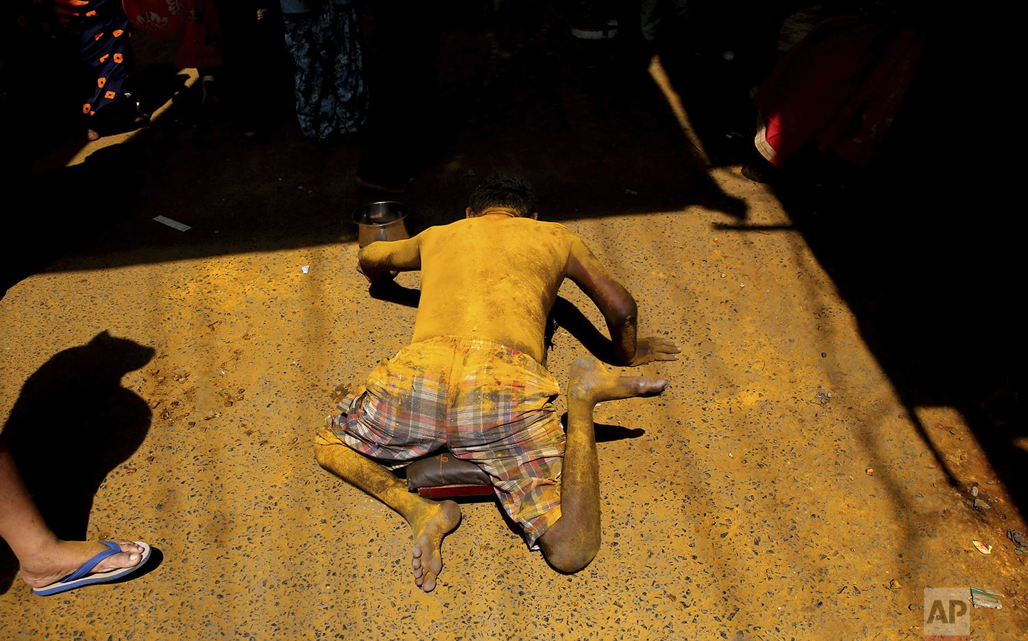 A man begs outside a temple during the celebration of the Bhandara Festival, or the Festival of Turmeric, at the Jejuri temple in Pune district, Maharashtra state, India, Monday, June 3, 2019. (AP Photo/Rafiq Maqbool)