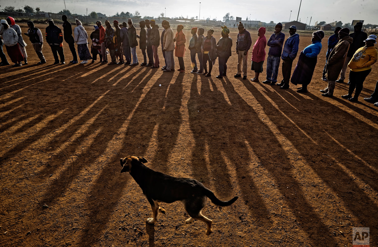 South Africans queue in the early morning sun to cast their votes in the mining settlement of Bekkersdal, west of Johannesburg, in South Africa Wednesday, May 8, 2019. (AP Photo/Ben Curtis)