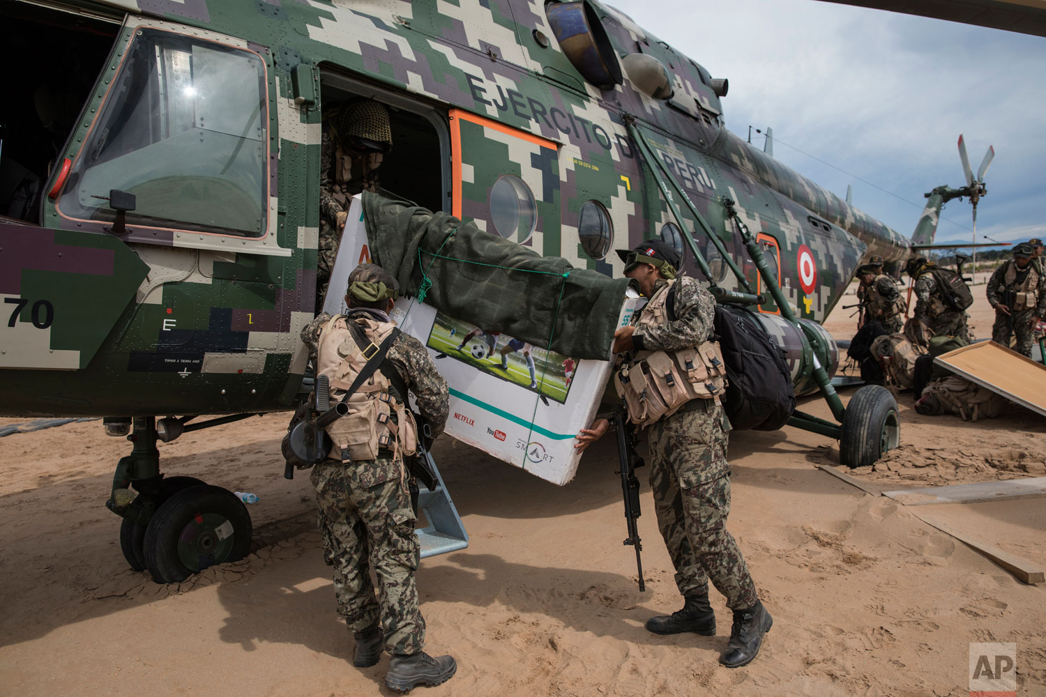 In this April 1, 2019 photo published May 15, completing their “Operation Mercury” tour, soldiers load their television in to a military helicopter, on a makeshift airstrip at the Balata military and police base in Peru's Tambopata province. (AP Photo/Rodrigo Abd)