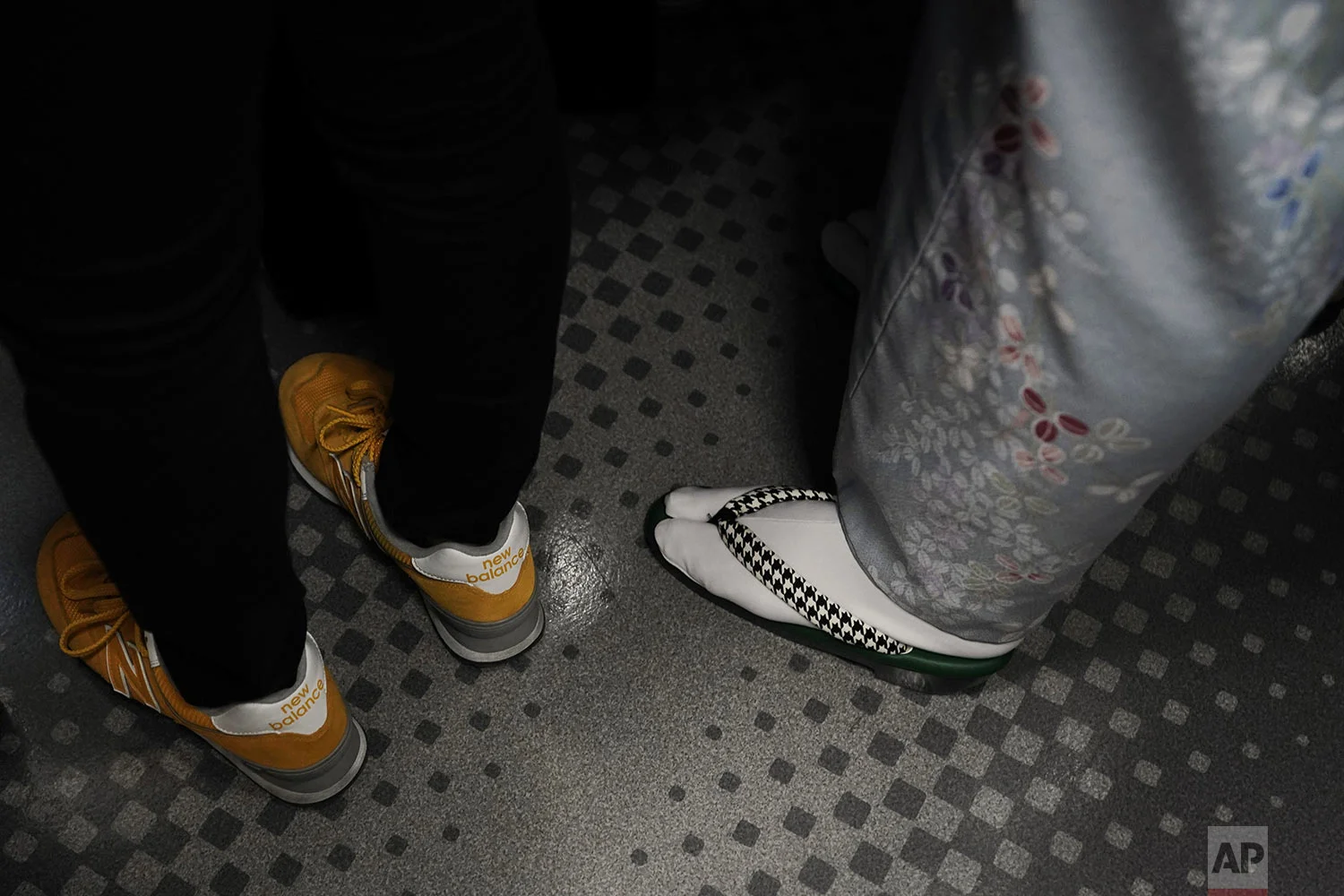 A woman wearing a kimono stands next to a young woman wearing sneakers in a packed train traveling along the Yamanote Line in Tokyo, Wednesday, May 22, 2019. (AP Photo/Jae C. Hong)